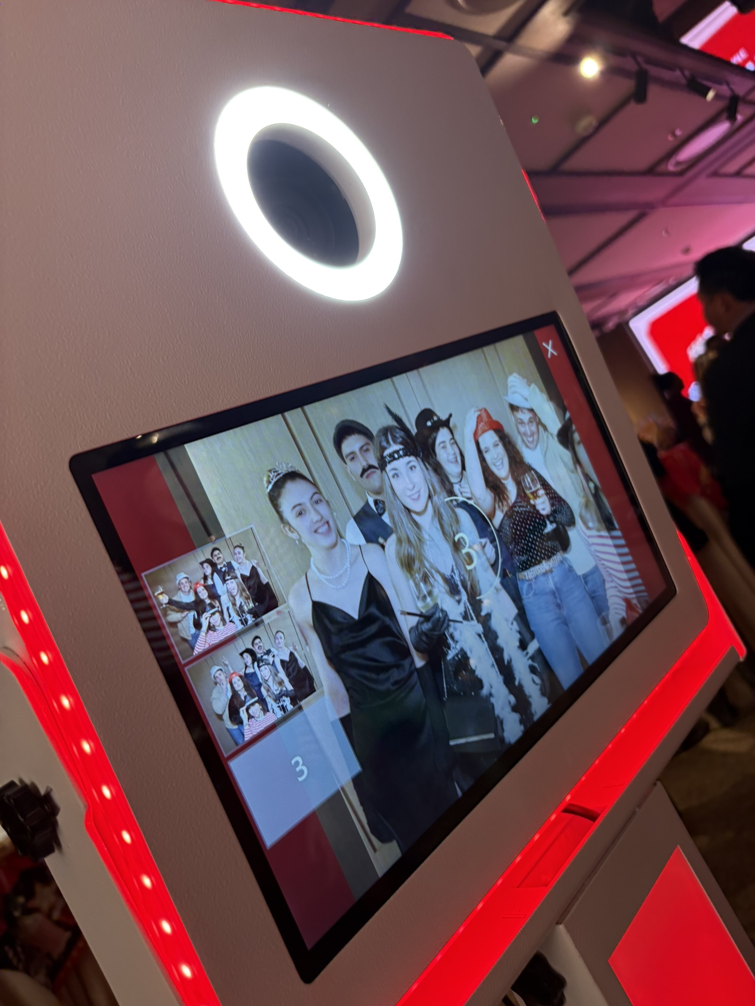 Fotomatón tótem con anillo de luz y pantalla táctil en un evento