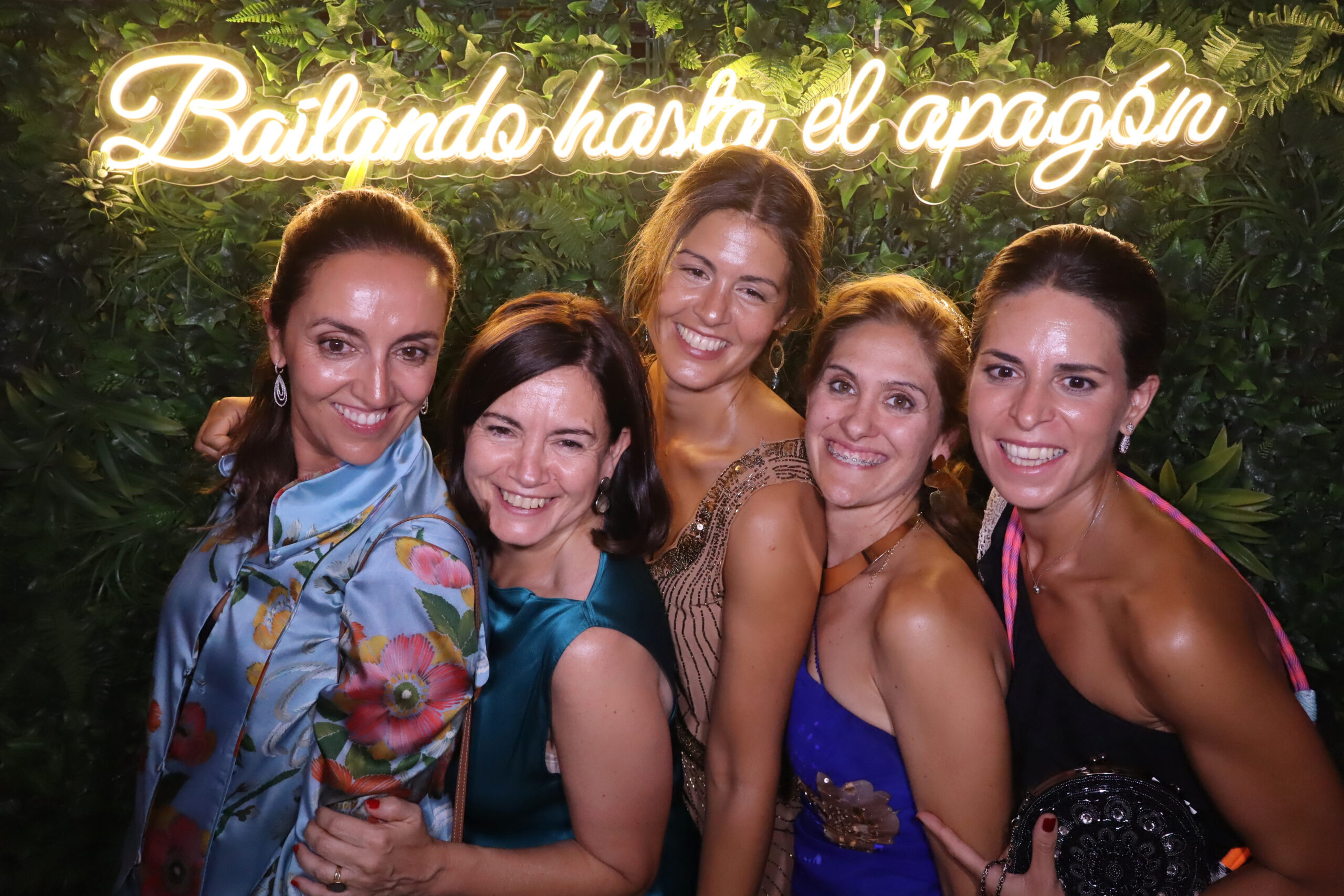 Grupo de invitadas en fotomatón con neón y fondo de verde